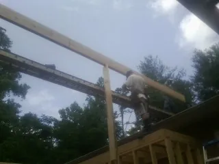 Carpenter setting a ridge beam over a new addition frame — Ice Dam Removal by Roofing Brothers in Deer Park